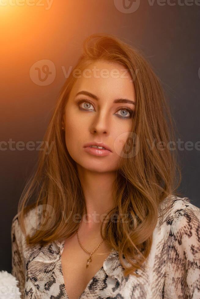 Portrait of a beautiful young business woman standing against grey background photo