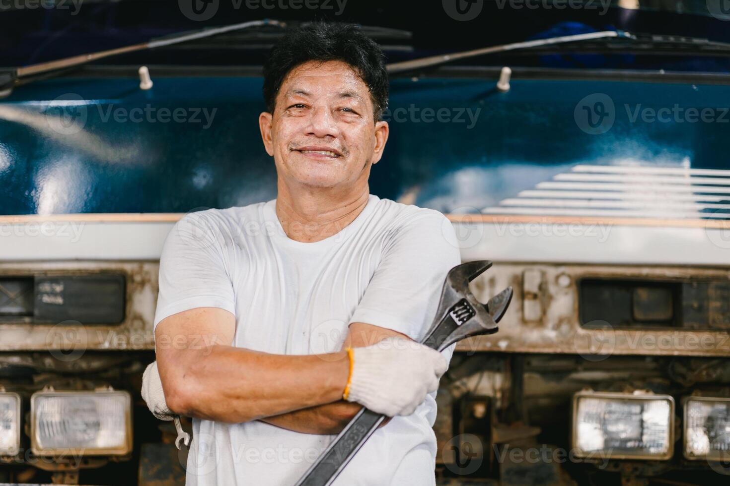 Portrait Auto Mechanic working in Garage Car service workshop. Confident workman arm crossing. photo
