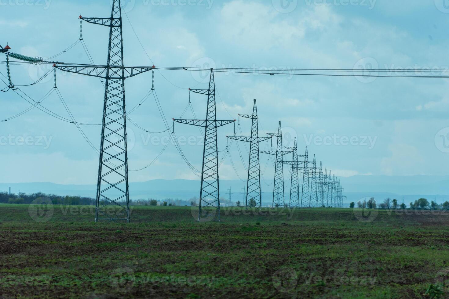 High voltage towers with sky background. Power line support with wires for electricity transmission. High voltage grid tower with wire cable at distribution station. Energy industry, energy saving photo