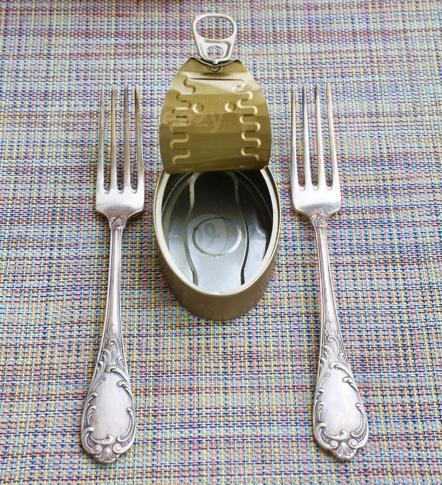 Empty tin can and two vintage forks. photo