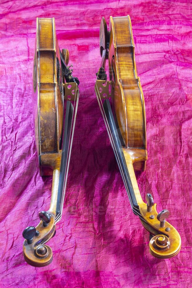 Two violins on a purple background. photo