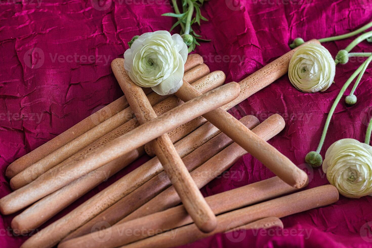 Grissini on the background of flowers and a red tablecloth. Breadsticks. Italian food. photo
