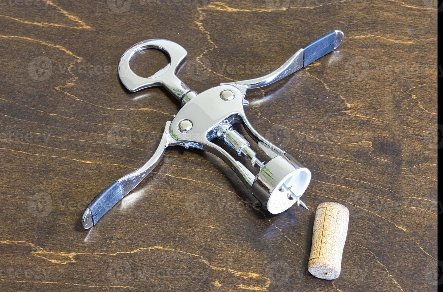 Corkscrew and cork on the table. photo