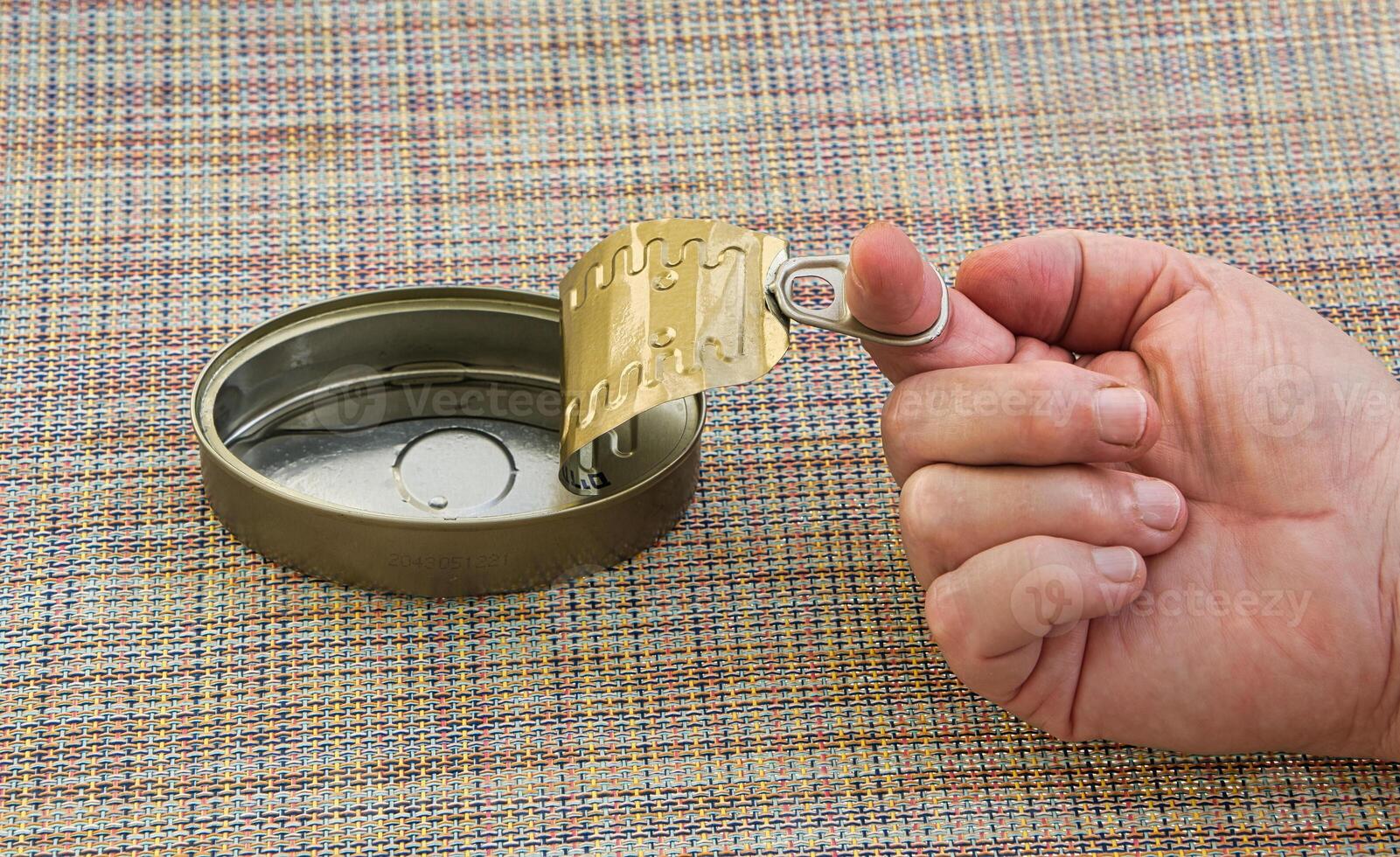 Hand opening a tin can. photo