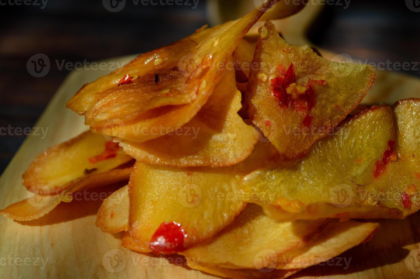 Keripik Singkong pedas or spicy Cassava Chips, Indonesian traditional snack. Made of cassava sliced, fried and cooked with chilli. photo