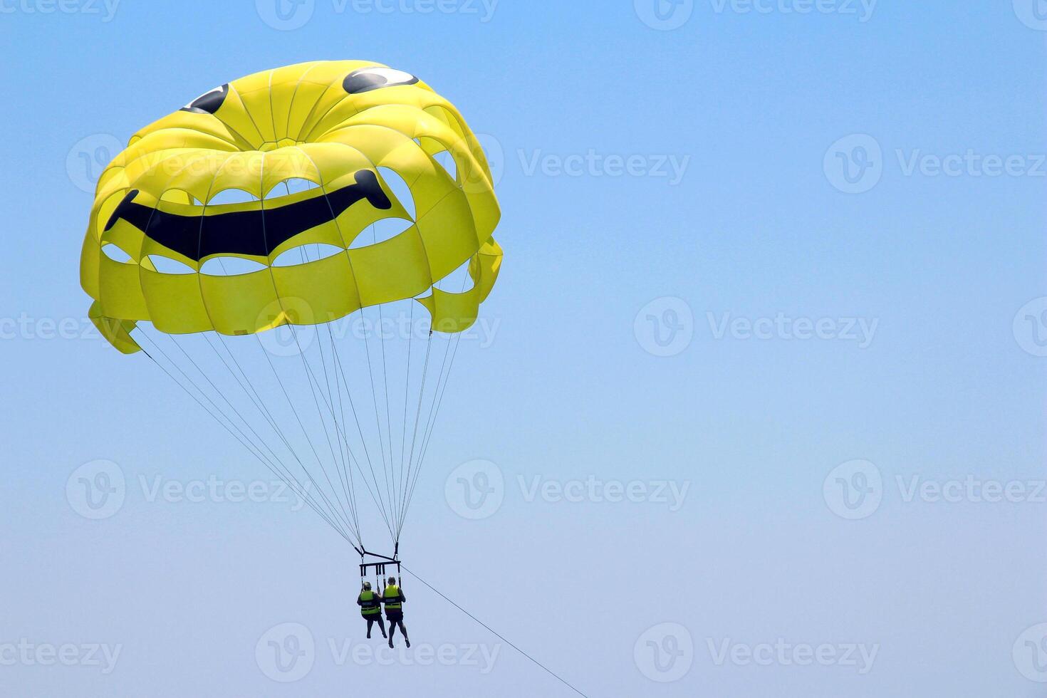 Parasailing, water activities, extreme sports, flying on a yellow parachute behind a boat during a summer holiday near the Mediterranean Sea in the resort of Cyprus. photo