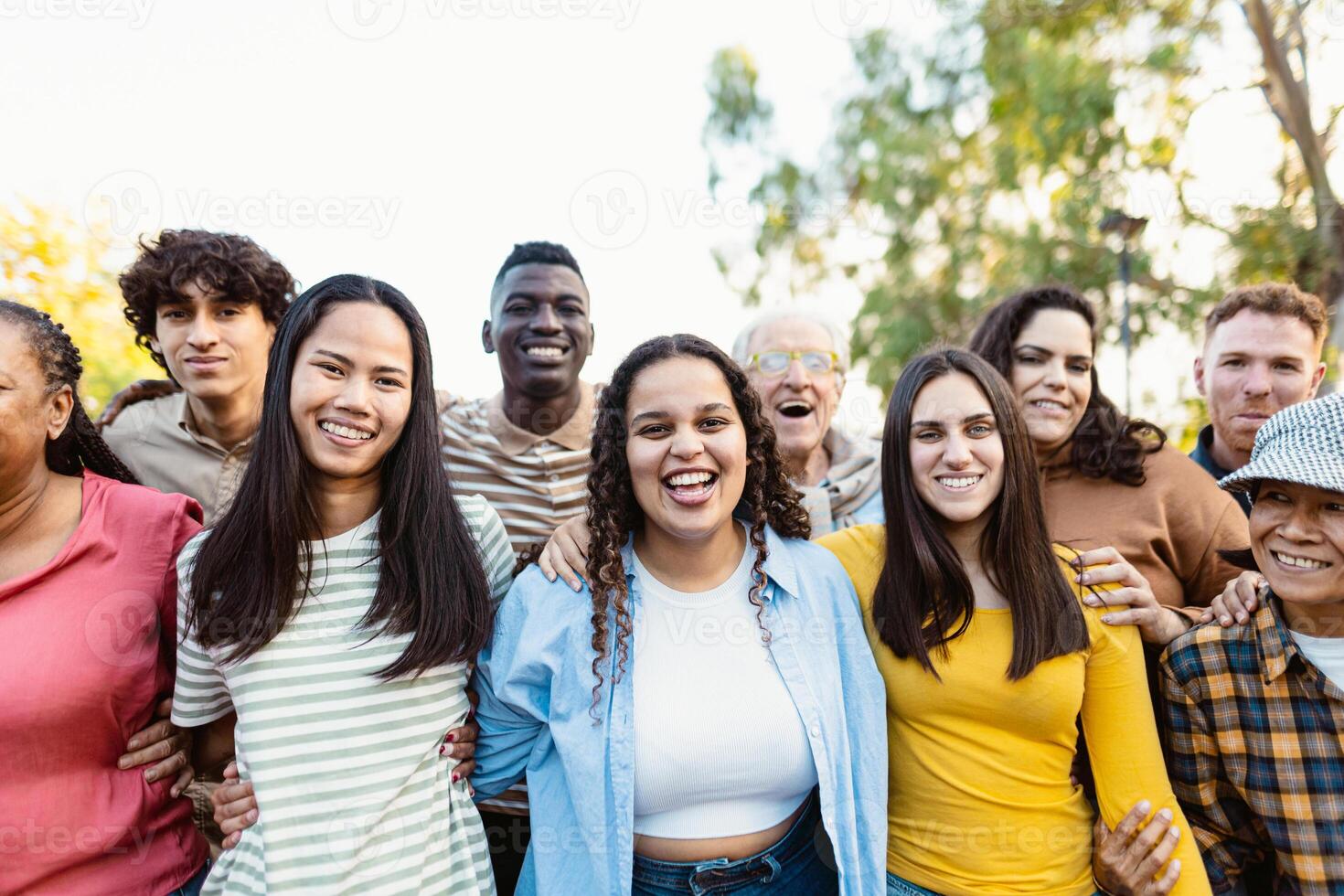 Happy multigenerational people with different ethnicities having fun together in a public park - Diversity concept photo