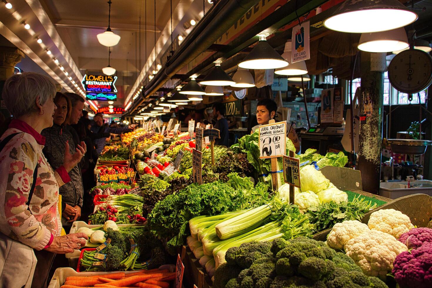 SEATTLE, WASHINGTON, USA 2017 Vegetables and fruits for sale in the high stalls at the Pike Place Market. This is a famous sight in downtown. photo