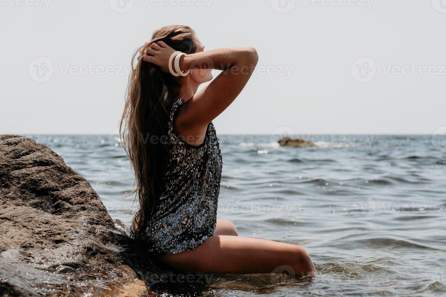 Woman summer travel sea. Happy tourist enjoy taking picture outdoors for memories. Woman traveler posing on the beach at sea surrounded by volcanic mountains, sharing travel adventure journey photo