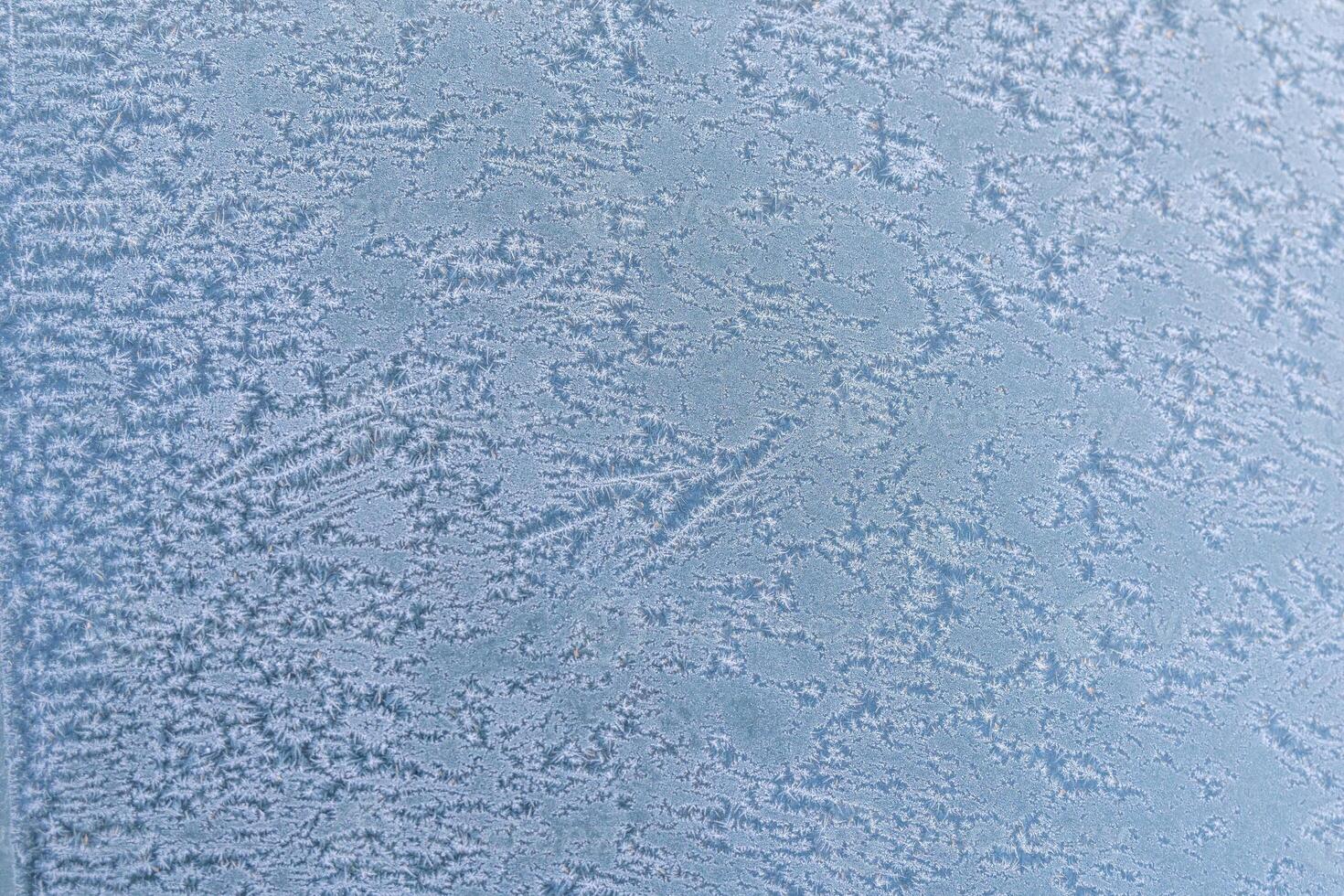 Selective focus. First frost on a frozen car, late autumn close-up. Beautiful abstract frozen microcosmos pattern. Freezing weather frost action in nature. Winter backdrop. photo