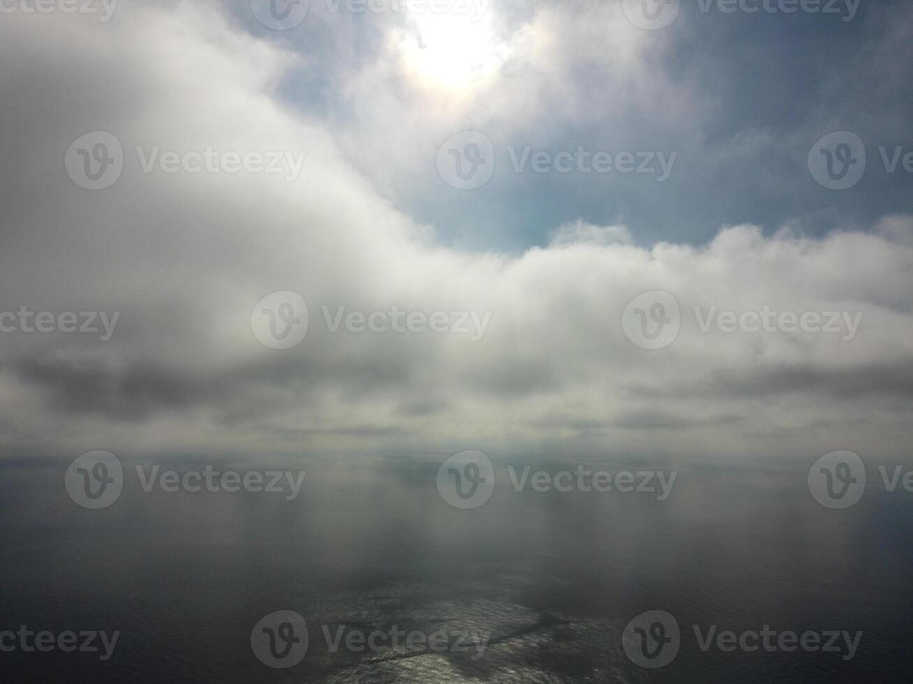 Aerial view. The drone flies over foggy and fluffy clouds. Blue sky sun and sea fog. Abstract aerial nature summer ocean sunset sea and sky background. Vacation, travel and holiday concept photo