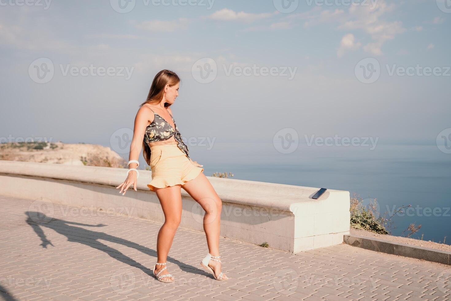 Woman summer dance. Silhouette of a happy woman who dances, spins and raises her hands to the sky. A playful young woman enjoys her happy moment dancing in the rays of the golden sun. photo