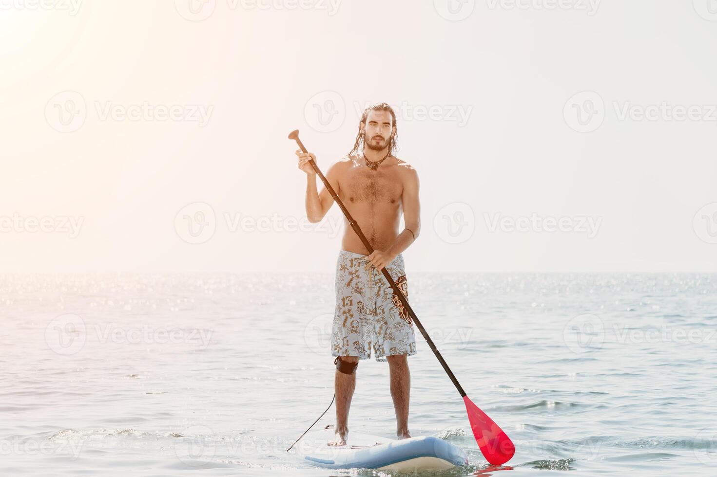 Man Sup Sea. Strong athletic man learns to paddle sup standing on board in open sea ocean on sunny day. Summer holiday vacation and travel concept. Aerial view. Slow motion photo