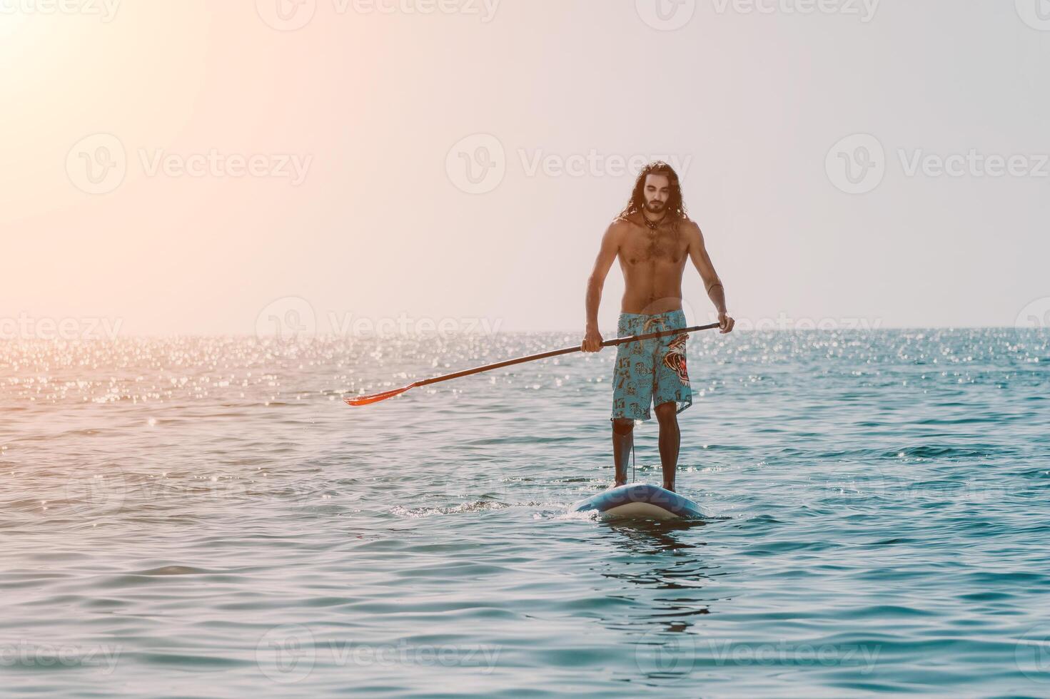Man Sup Sea. Strong athletic man learns to paddle sup standing on board in open sea ocean on sunny day. Summer holiday vacation and travel concept. Aerial view. Slow motion photo