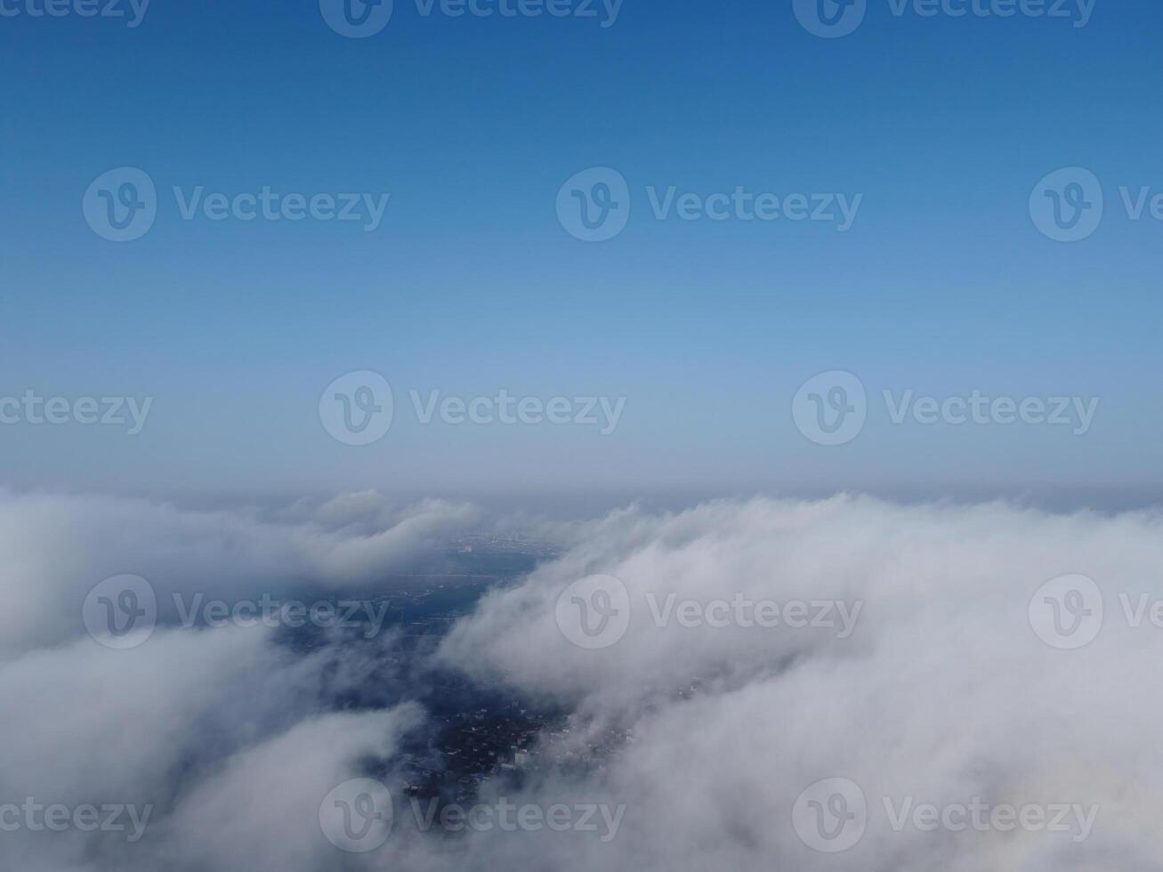 High above the thick fog, like beautiful ocean of clouds at sunrise. Sun is rising above the endless sea of clouds until the horizon. Amazing nature landscape photo