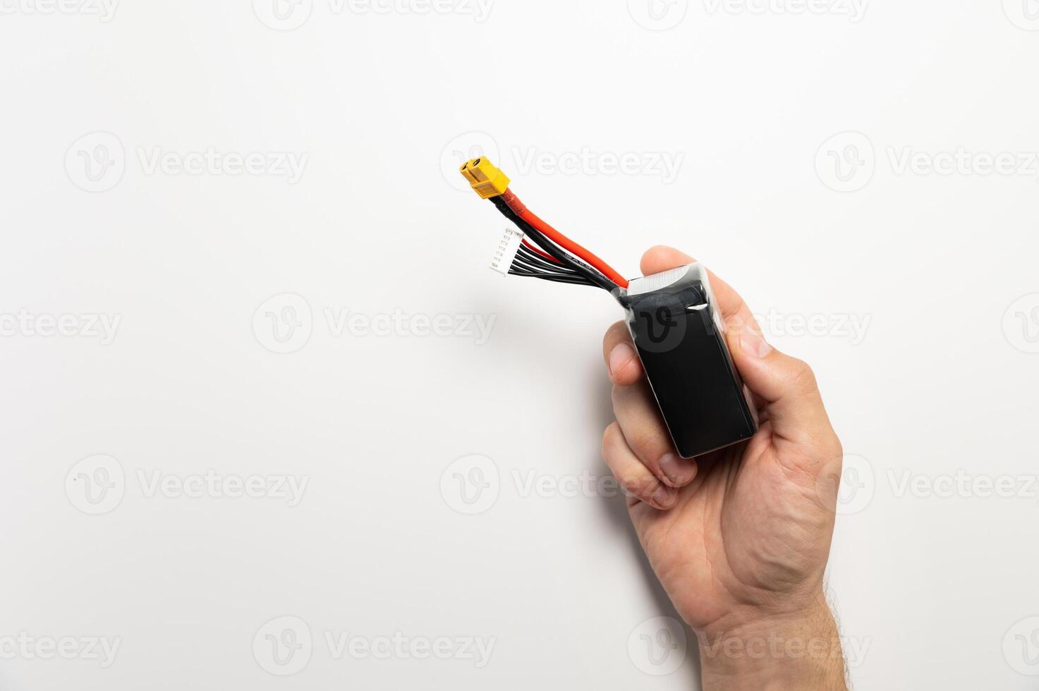 A man's hand holds a six-cell Lithium Polymer battery. On a white background. Lithium technology photo