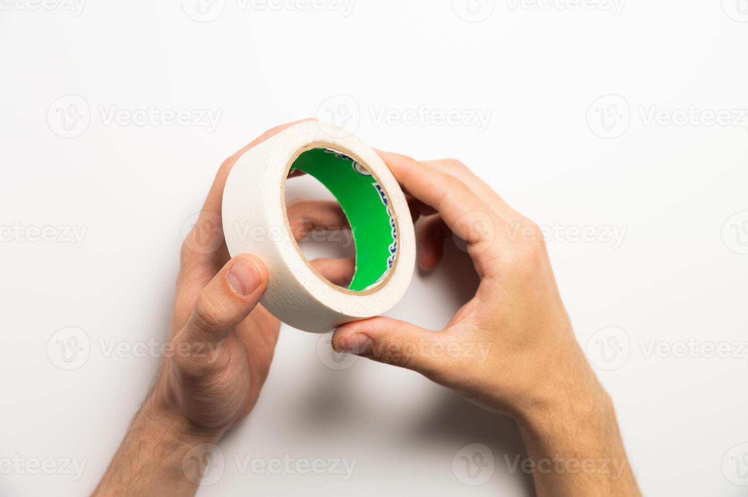 Hands holding adhesive tape on a white background. Masking tape in your hands photo