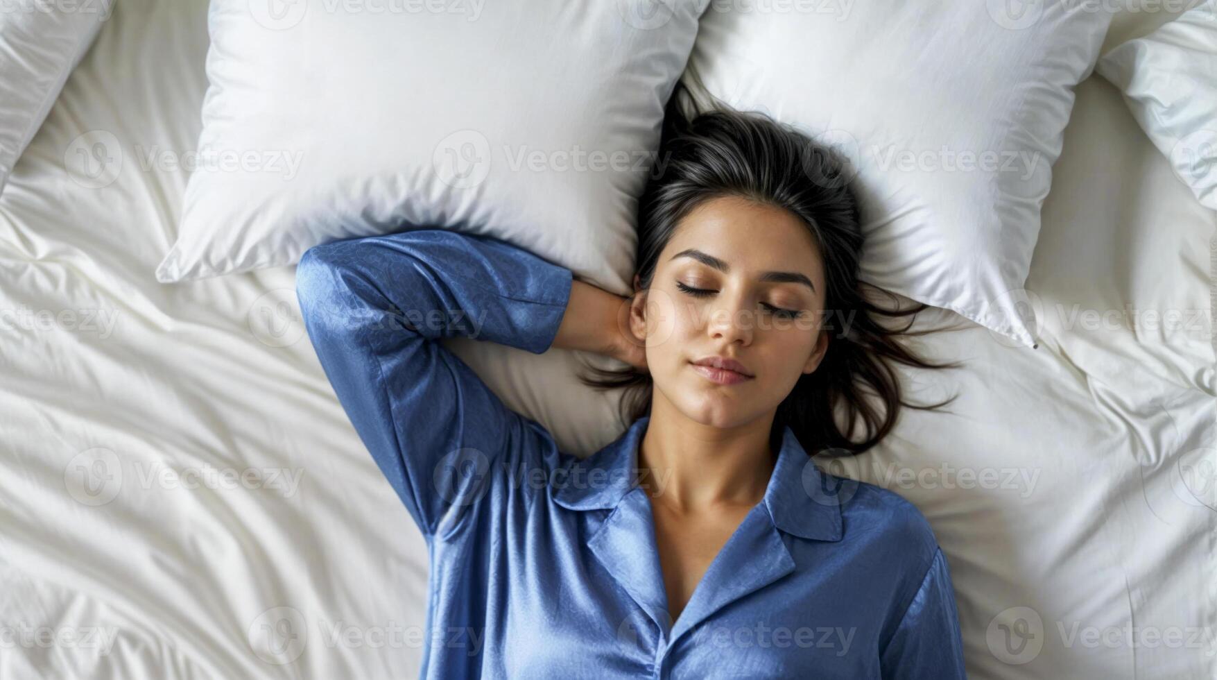 Woman sleeping peacefully on bed with blue pajamas photo