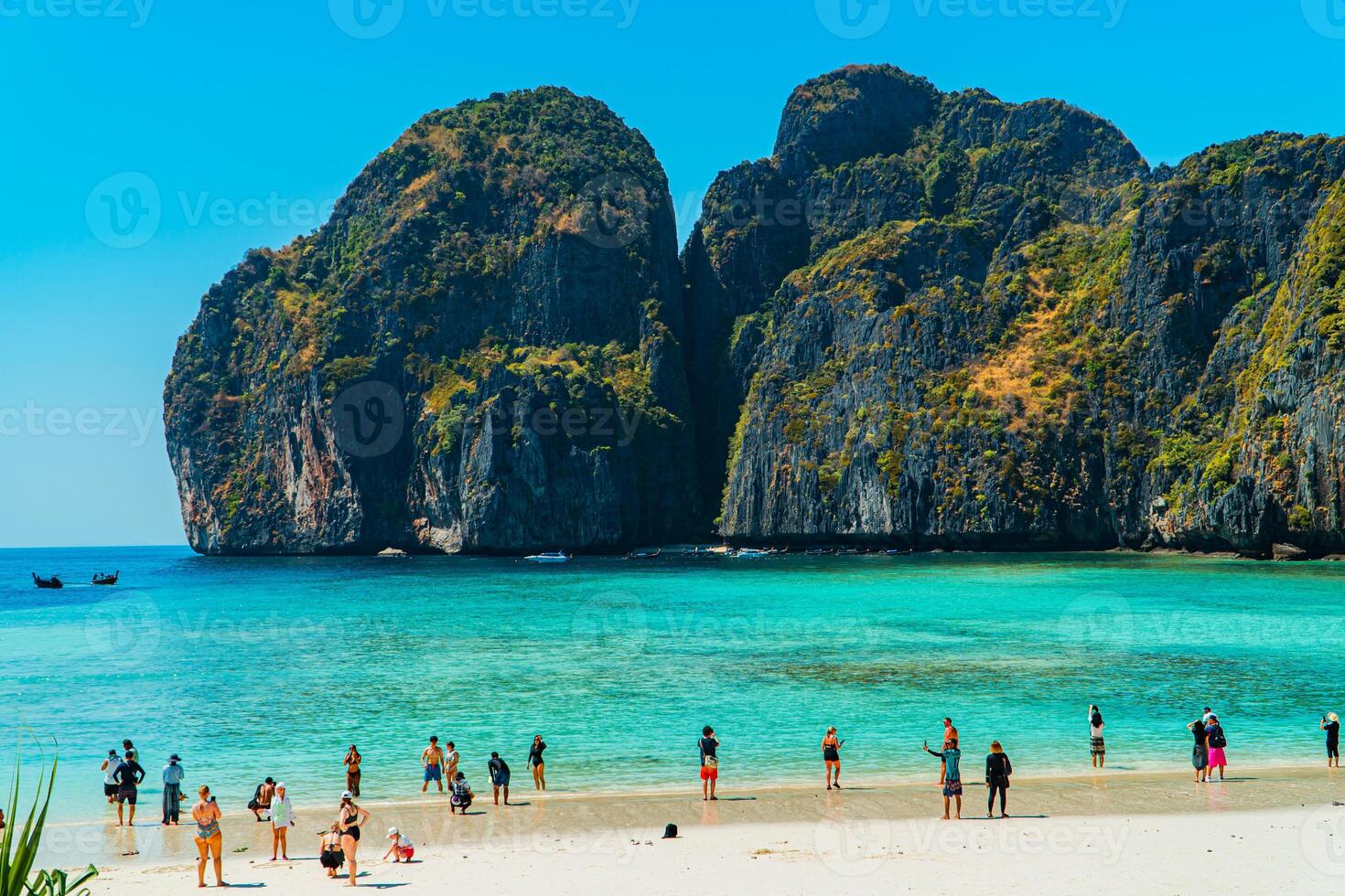 Beautiful natural view of Maya Bay during the day. Popular tourist destination on Phi-phi Island, Thailand during high season with clear sea water, white sand and very iconic high cliffs photo