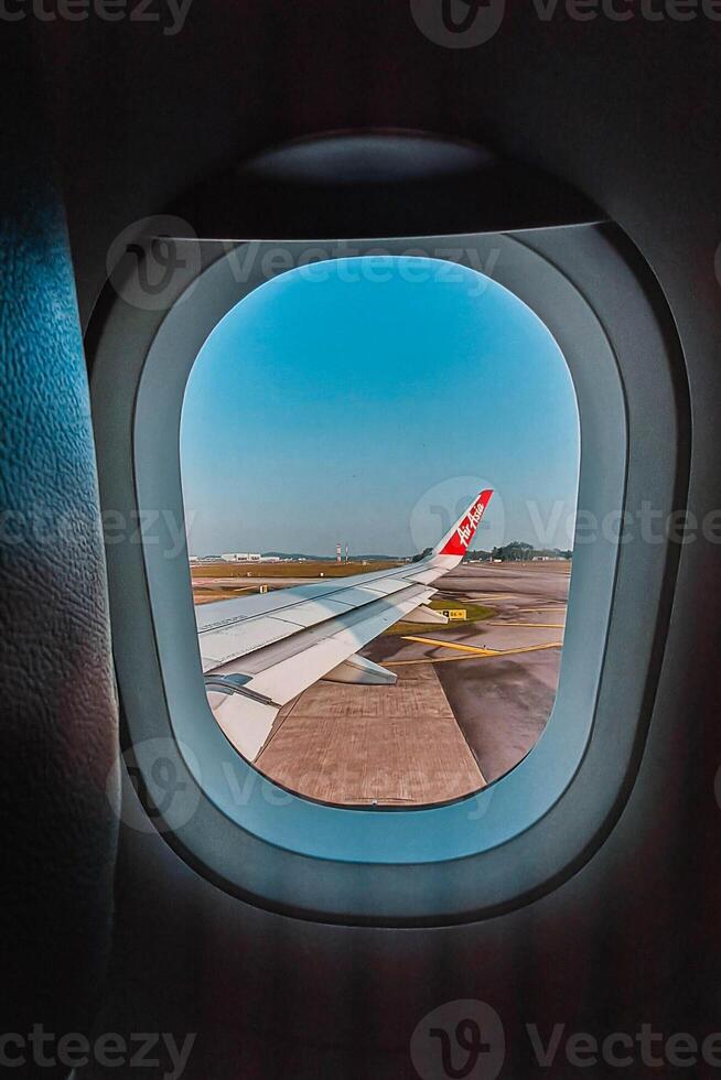 Footage of a clear, white cloudy sky from a commercial airplane window. The view from inside the plane is a daytime sky with white clouds moving smoothly photo