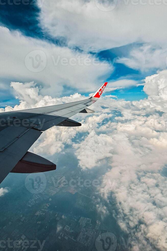 Footage of a clear, white cloudy sky from a commercial airplane window. The view from inside the plane is a daytime sky with white clouds moving smoothly photo