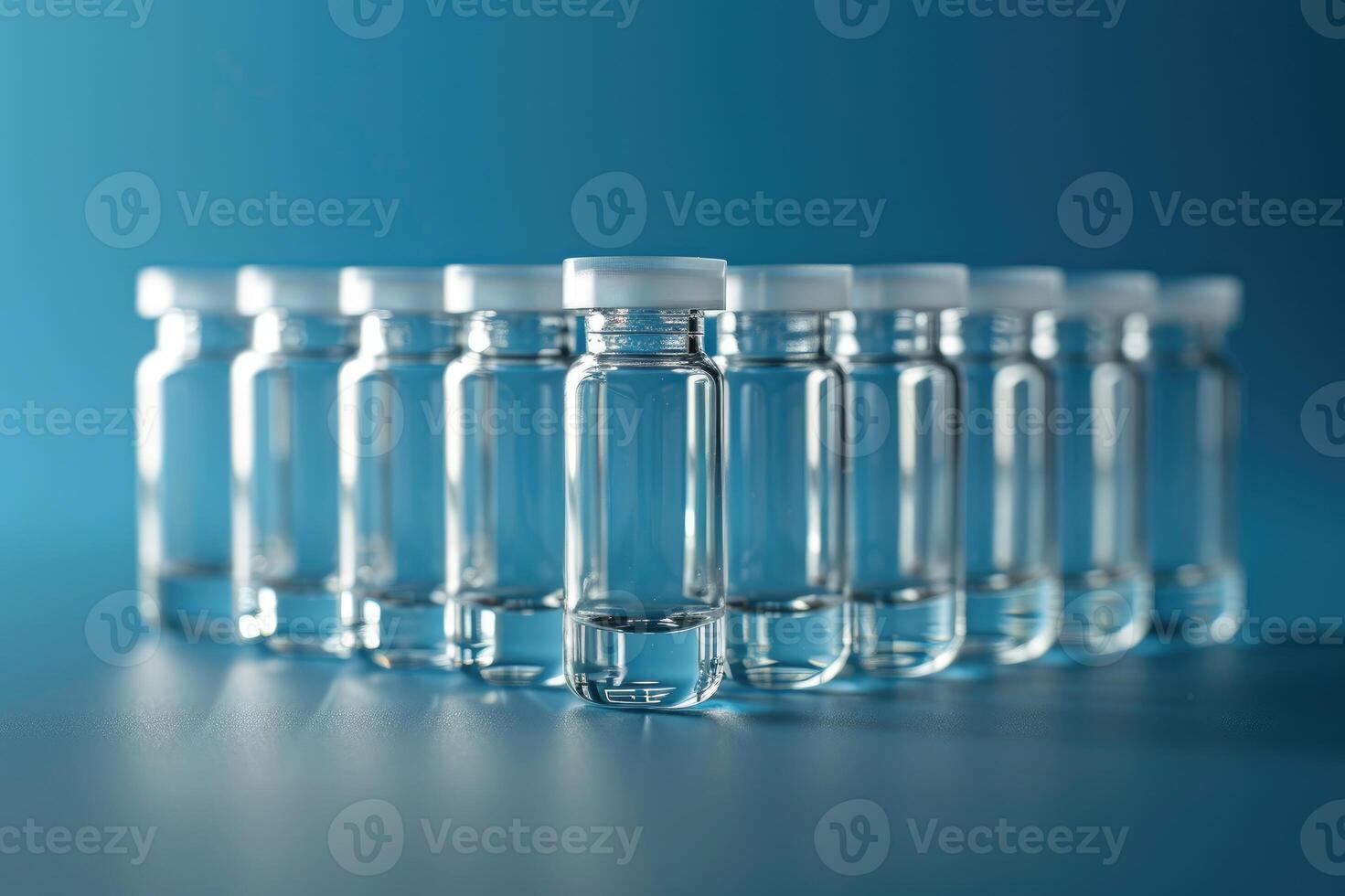 Transparent medical vials on a blue surface for healthcare, medical or scientific investigation photo