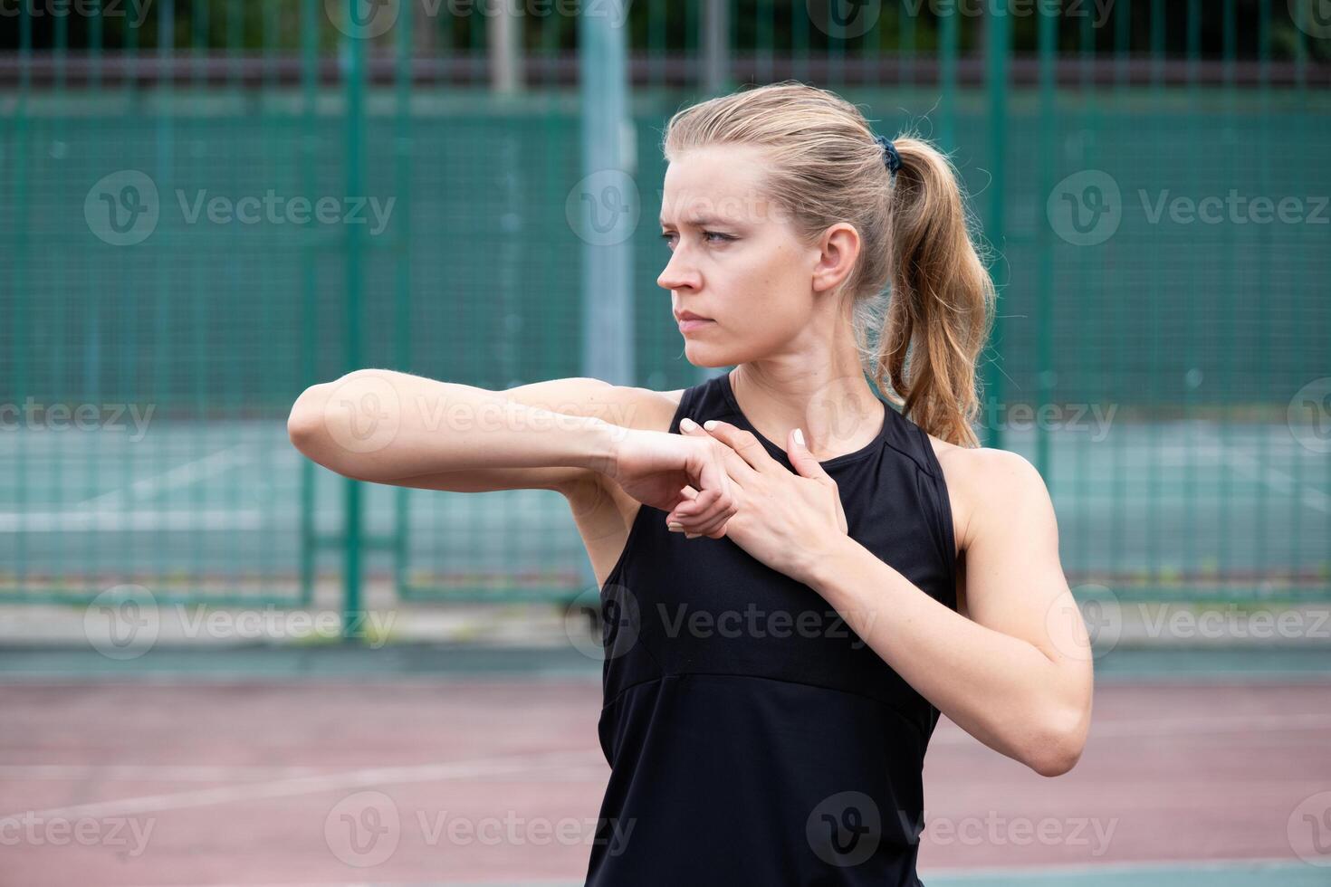 Caucasian sportive female boxer training at the stadium, warming up and stretching photo