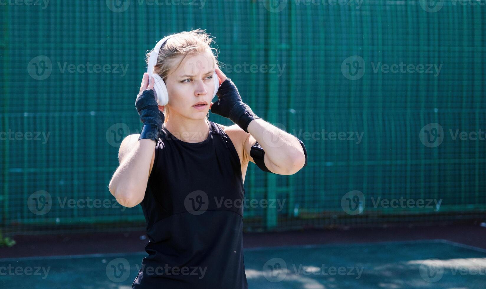 young female boxer training in the stadium standing in position photo