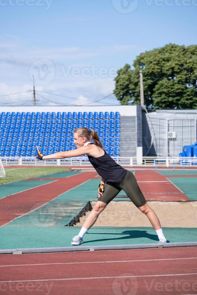 young female boxer training in the stadium, warming up photo
