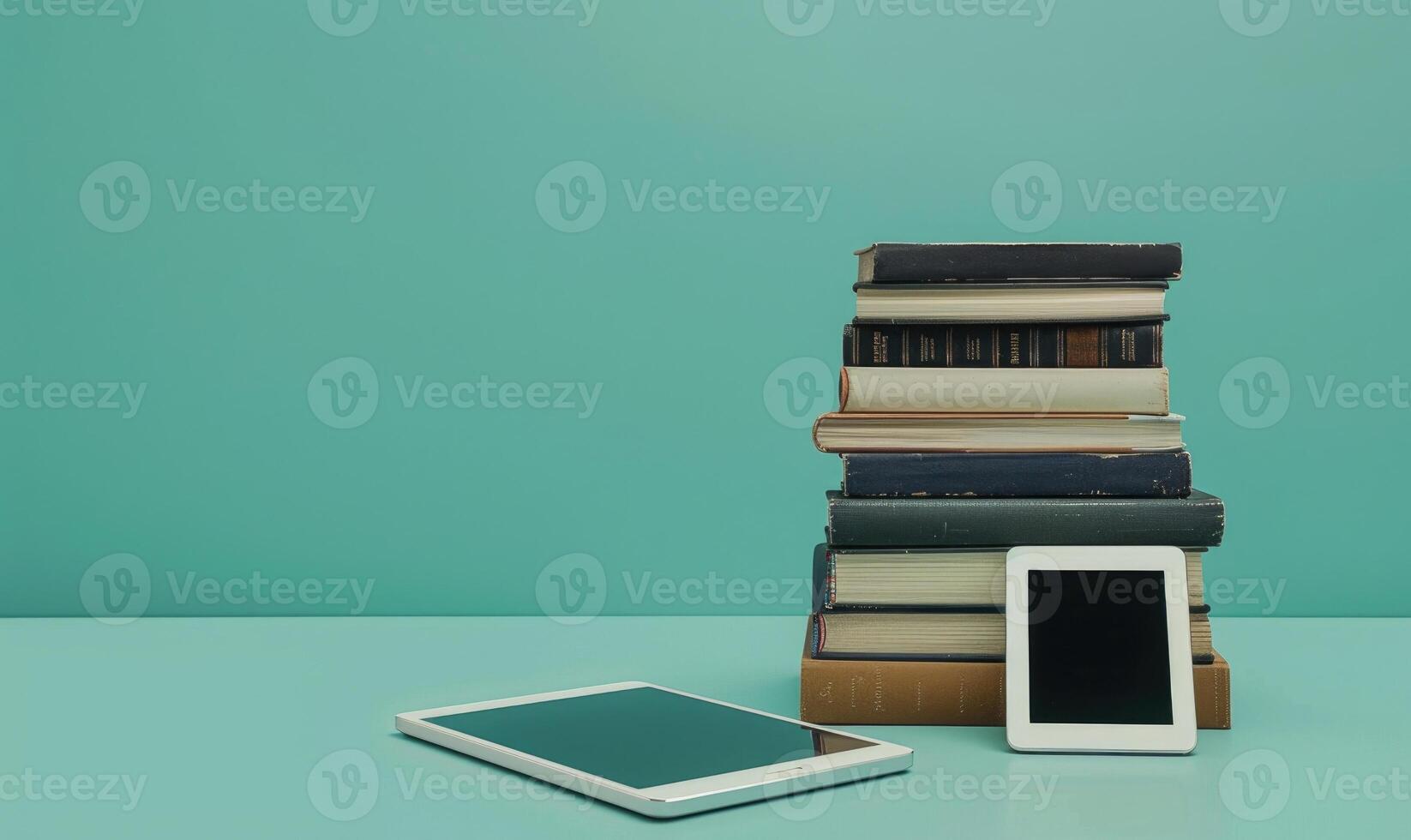 Stack of books on a light gray table with a pastel turquoise background photo