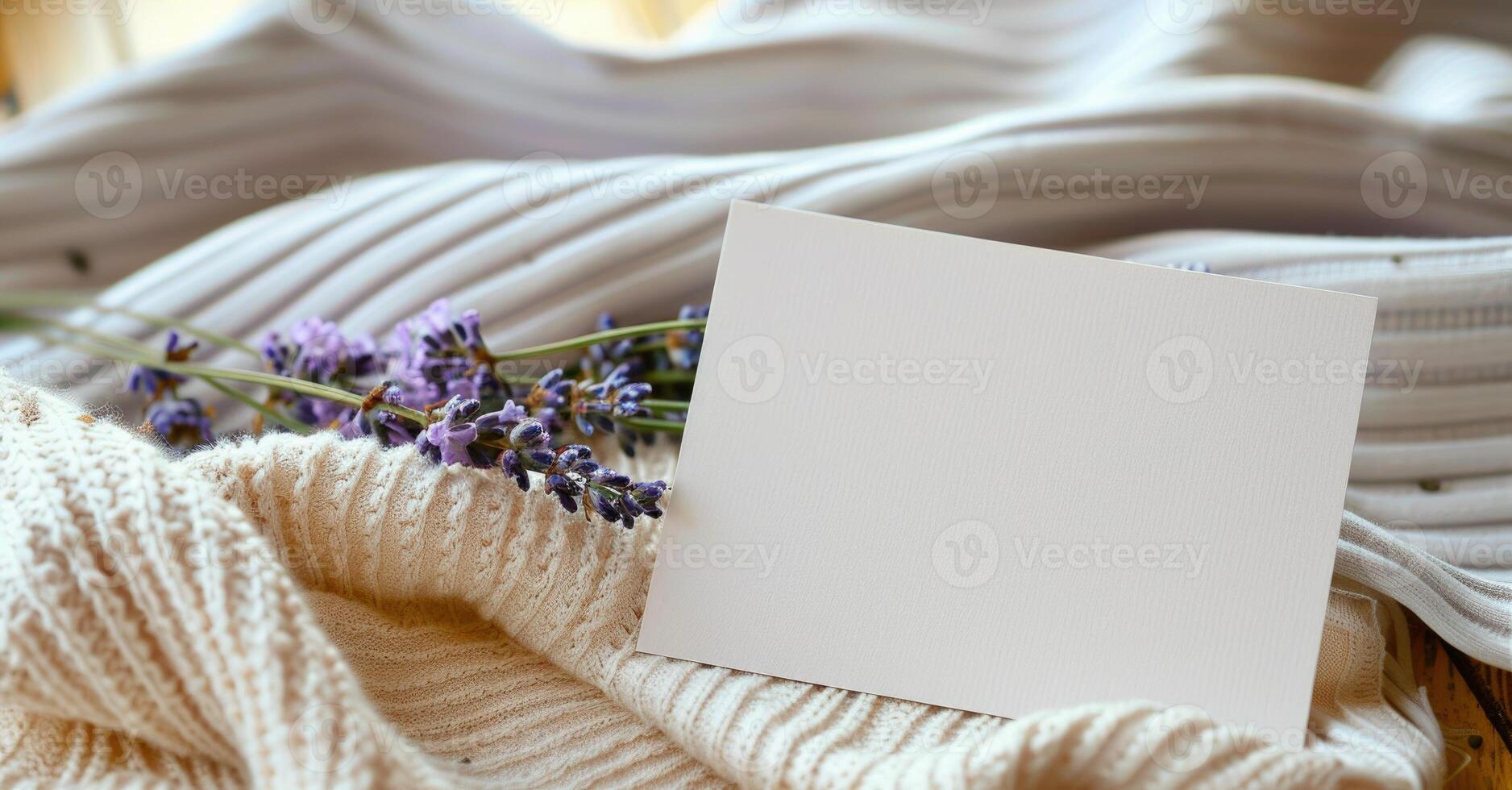 White blank card on a pastel butter yellow table, with a knitted cloth and a small lavender bunch photo