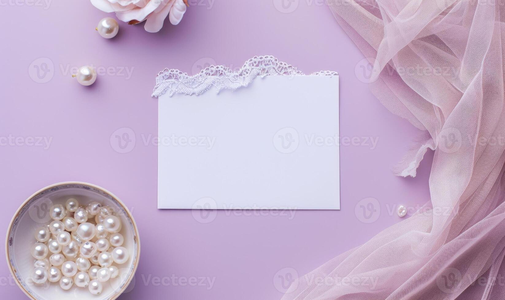 White blank card on a pastel lavender background, with a silk scarf and a pearl necklace photo