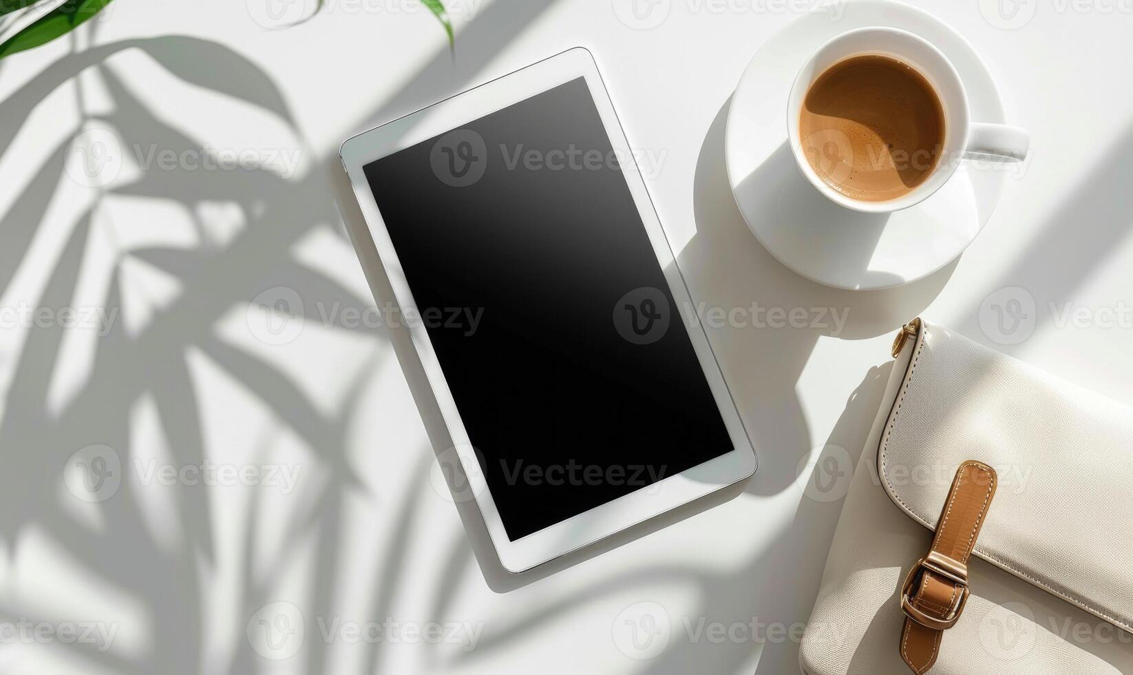Tablet on a light gray table with a cup of tea on the left, sunlight from window photo