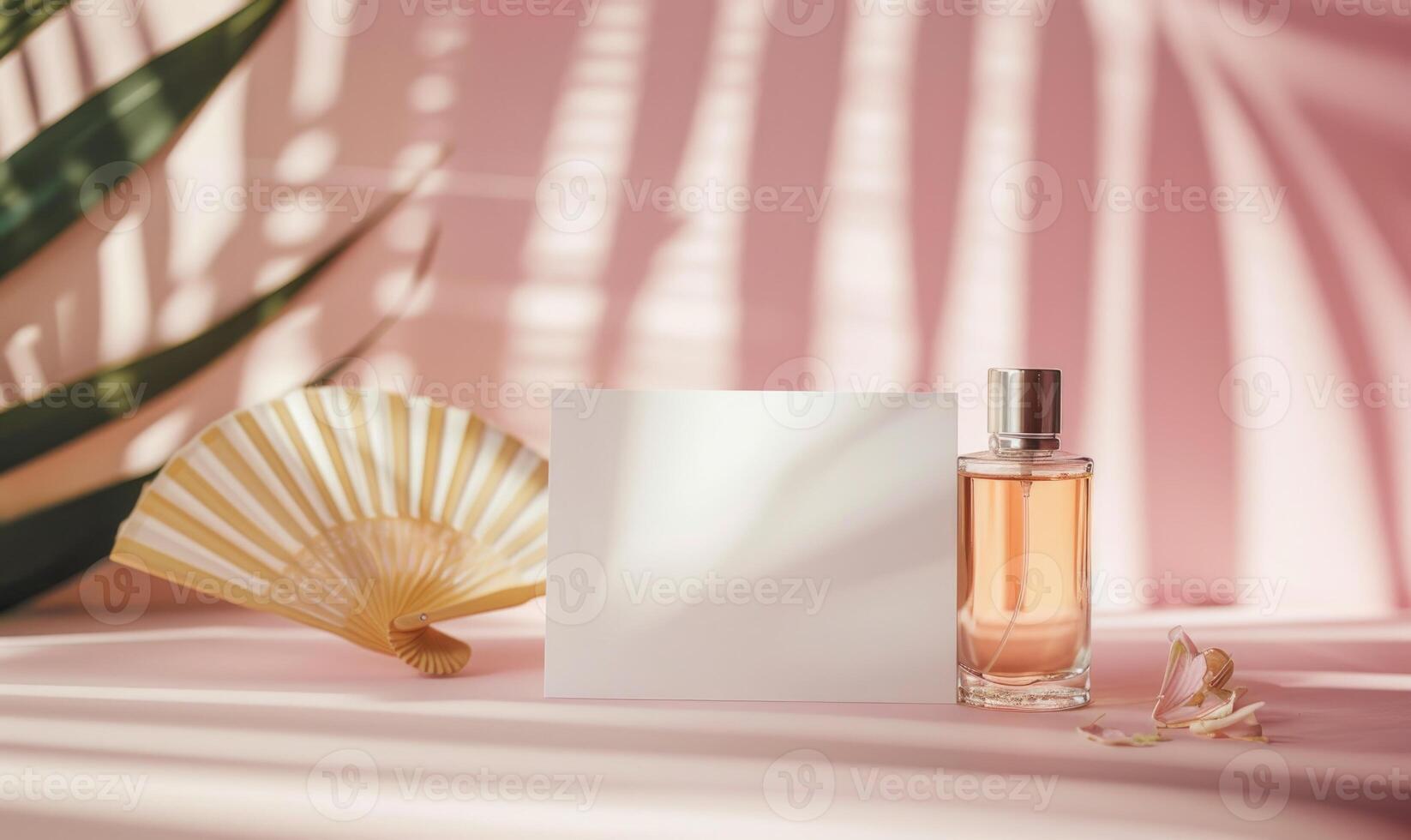 White blank card on a pastel pink table, with a delicate hand fan and a small perfume bottle photo