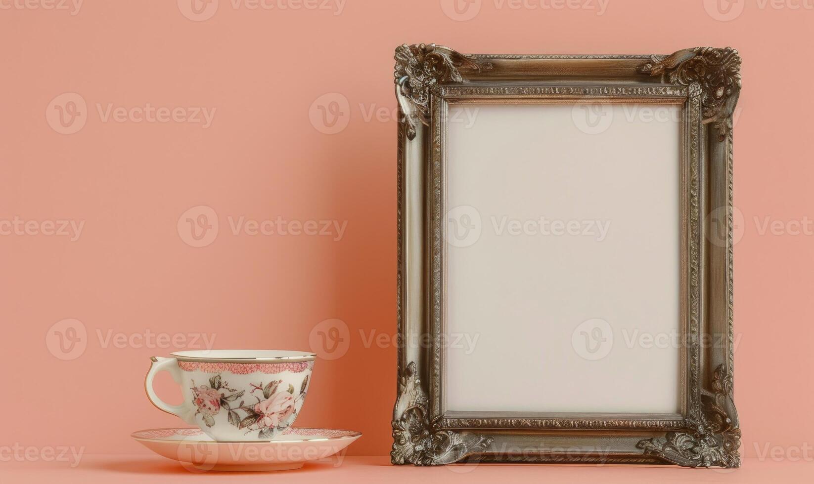 White blank card in a vintage silver frame on a pastel peach background, with a vintage tea cup photo