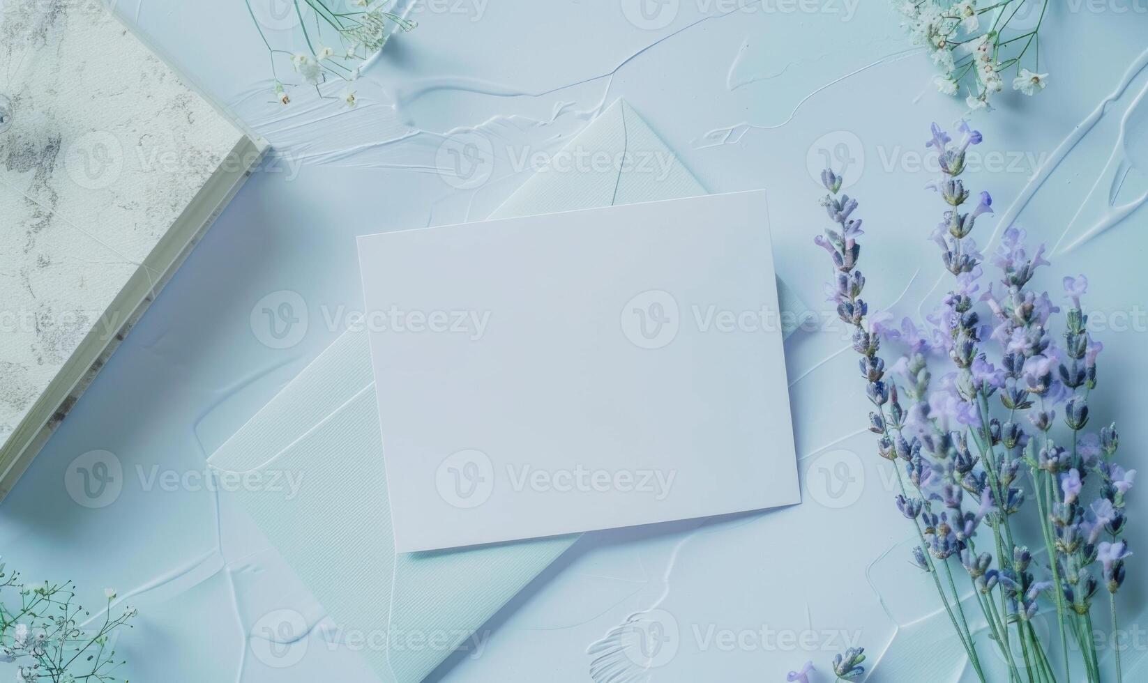 White blank card on a pastel periwinkle table, with a sprig of lavender and a small notebook photo