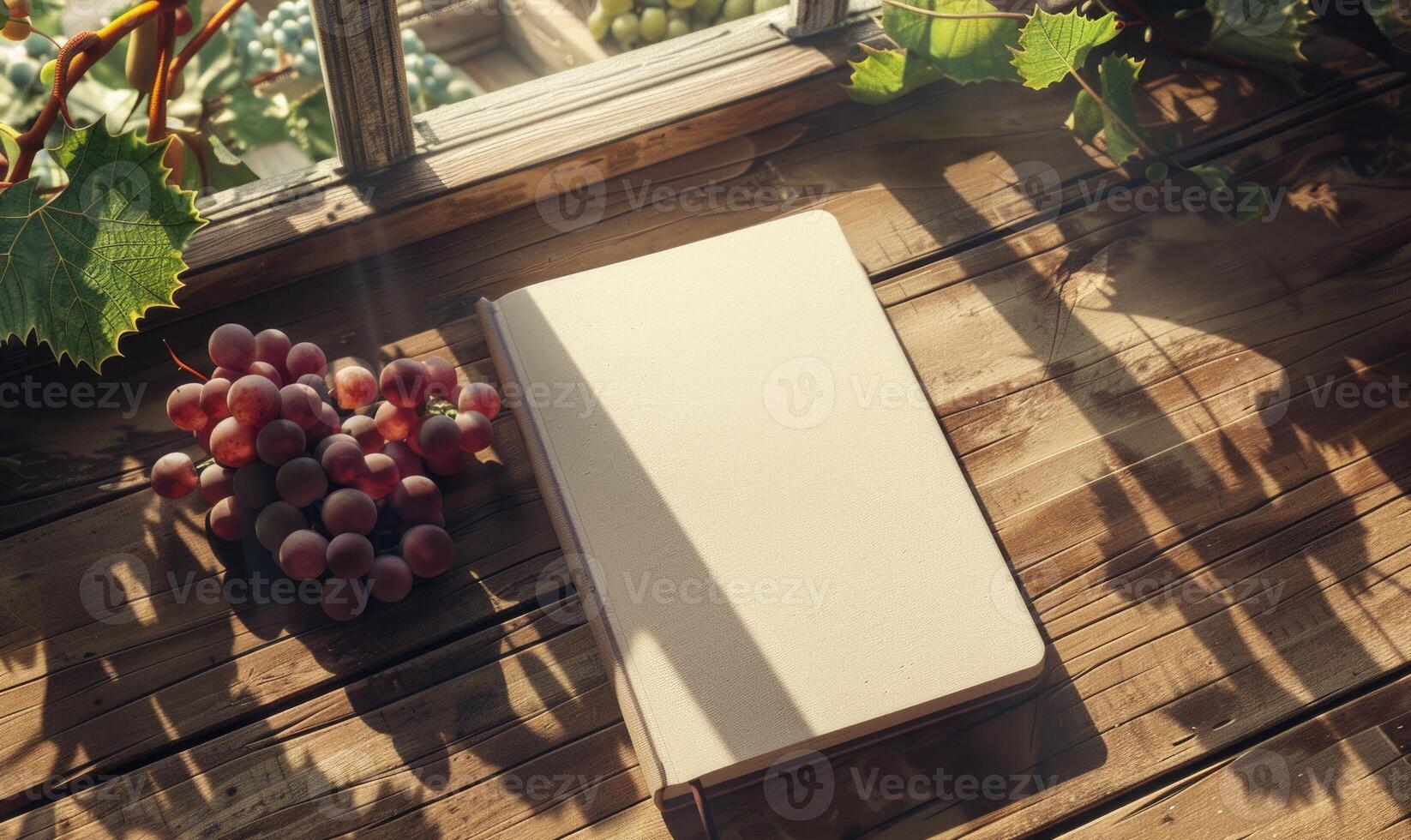 Notebook on a wooden table with a bunch of grapes photo