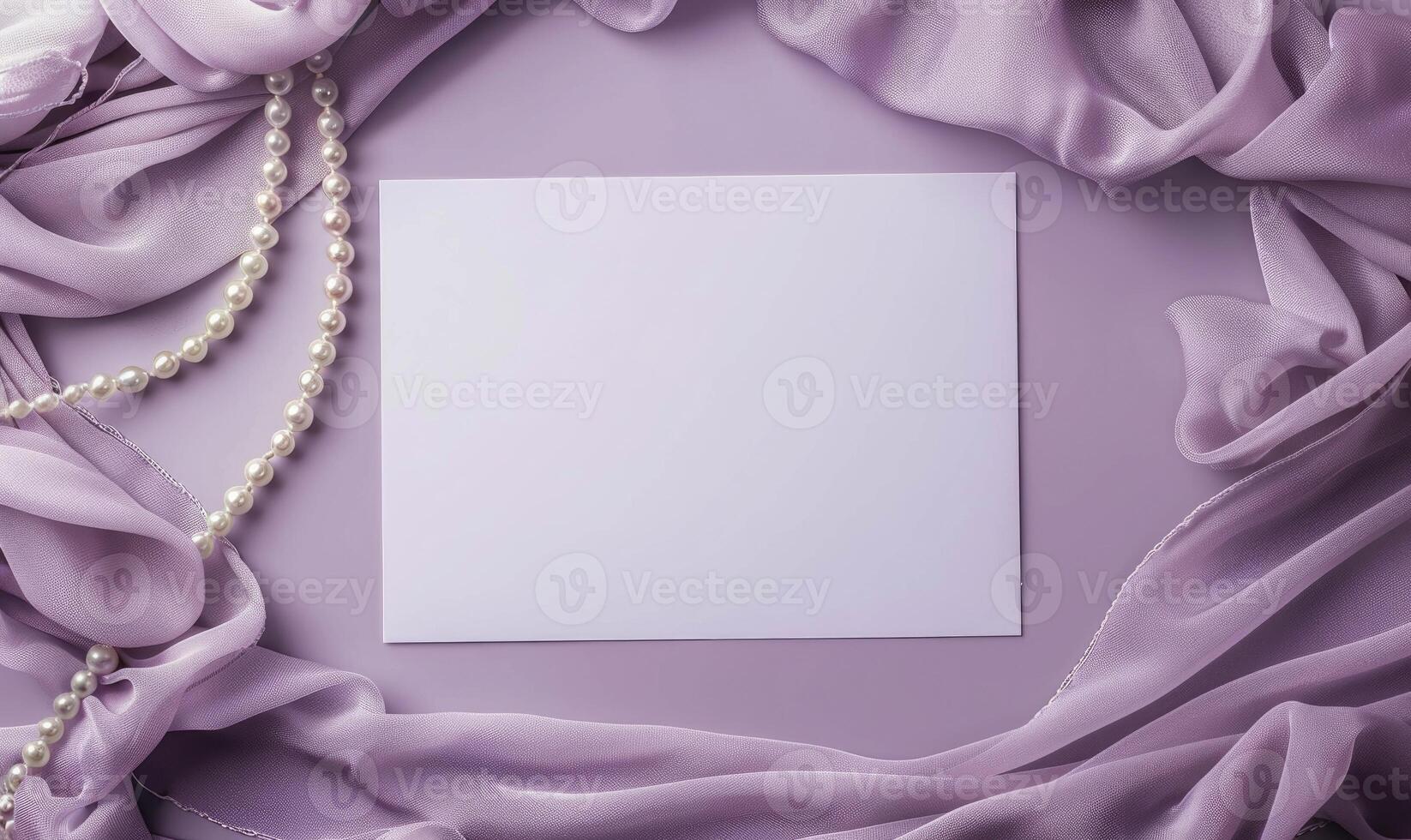 White blank card on a pastel lavender background, with a silk scarf and a pearl necklace photo