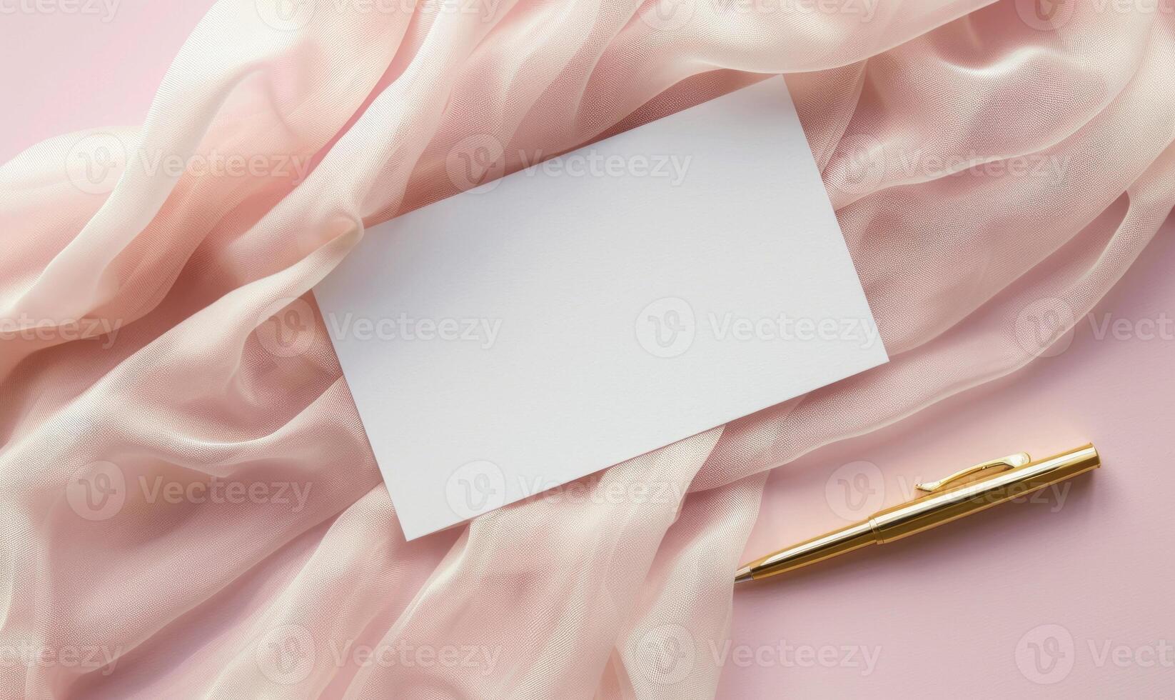 White blank card on a pastel blush pink background, with a piece of chiffon fabric and a gold pen photo