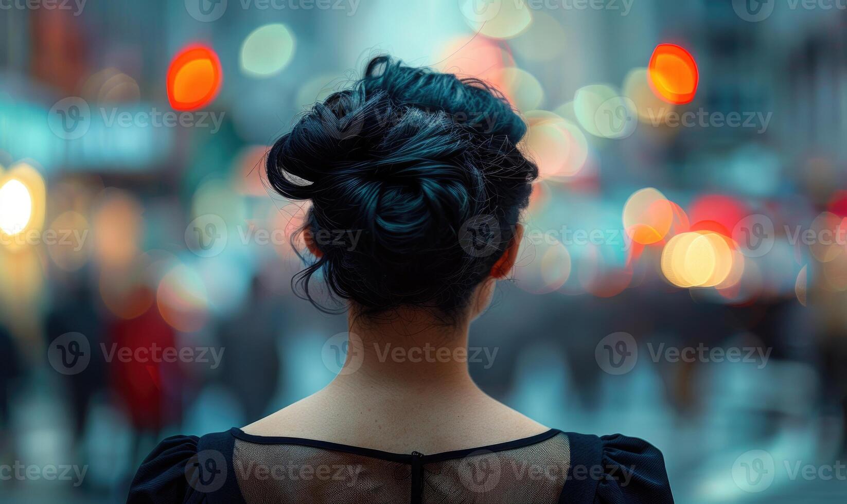 An elegant woman with short black hair, styled neatly in a bun, looking on the street photo