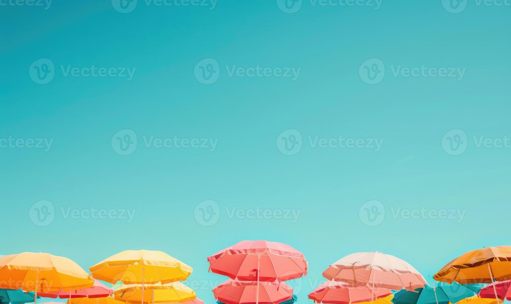 A beach dotted with colorful umbrellas under a clear blue sky, summer tourism background photo