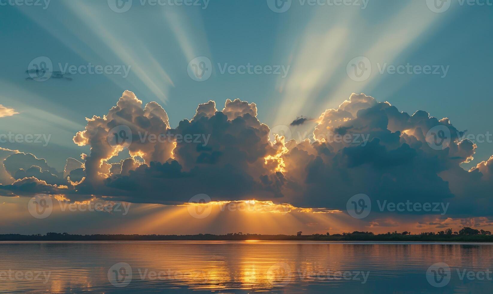 The sun peeking through a fluffy cumulus clouds, clouds reflected in water surface, sunset on the lake photo