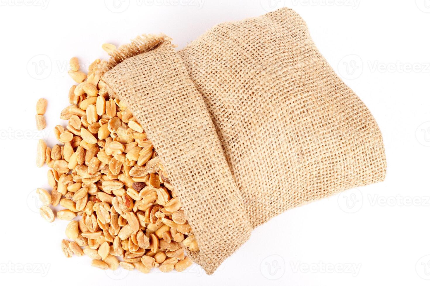 peeled roasted peanuts in rustic bag isolated on white background photo