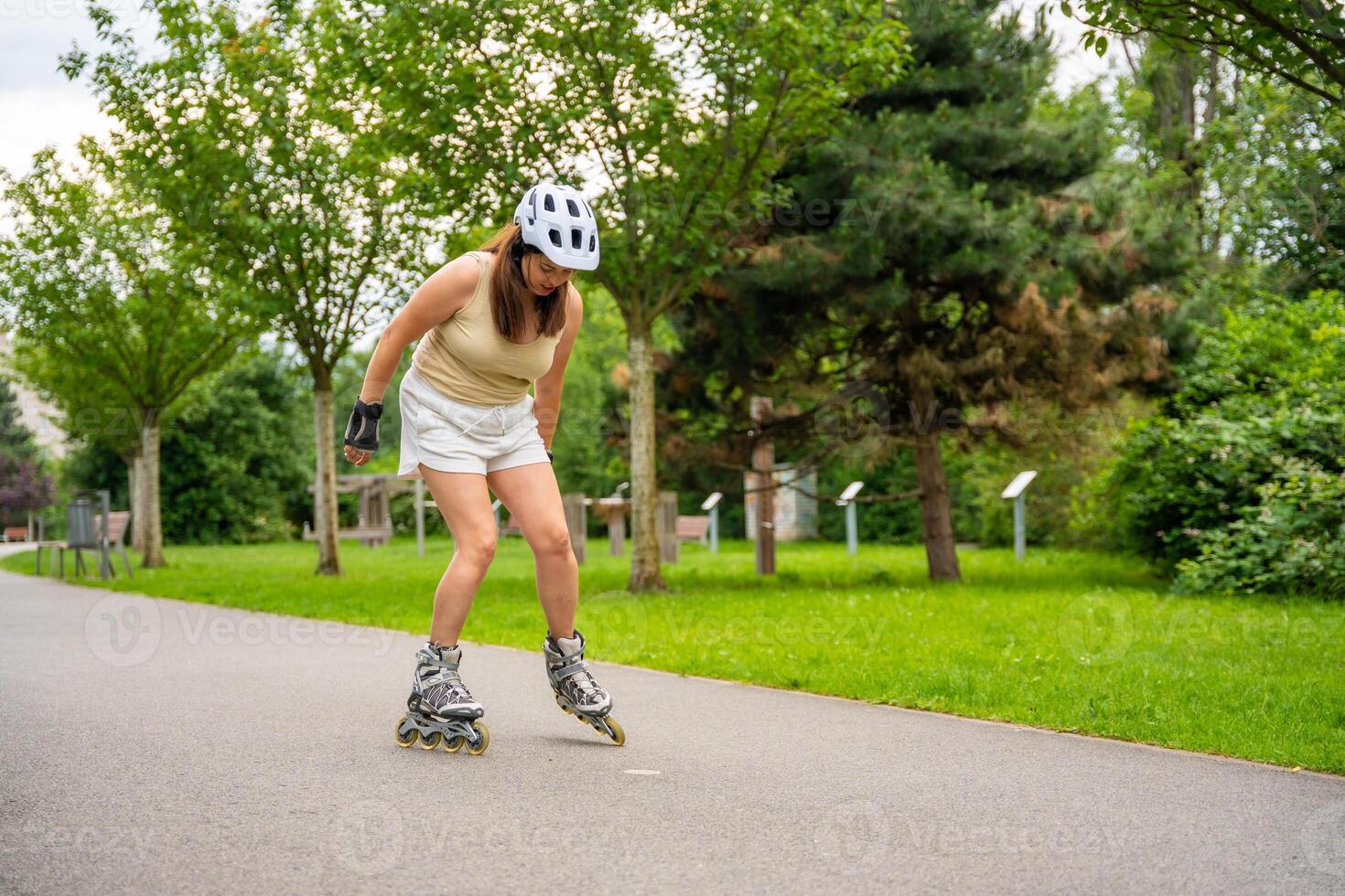 Roller skater woman in park rollerblading on inline skates. Outdoor activities. Summer roller skating. High quality photo