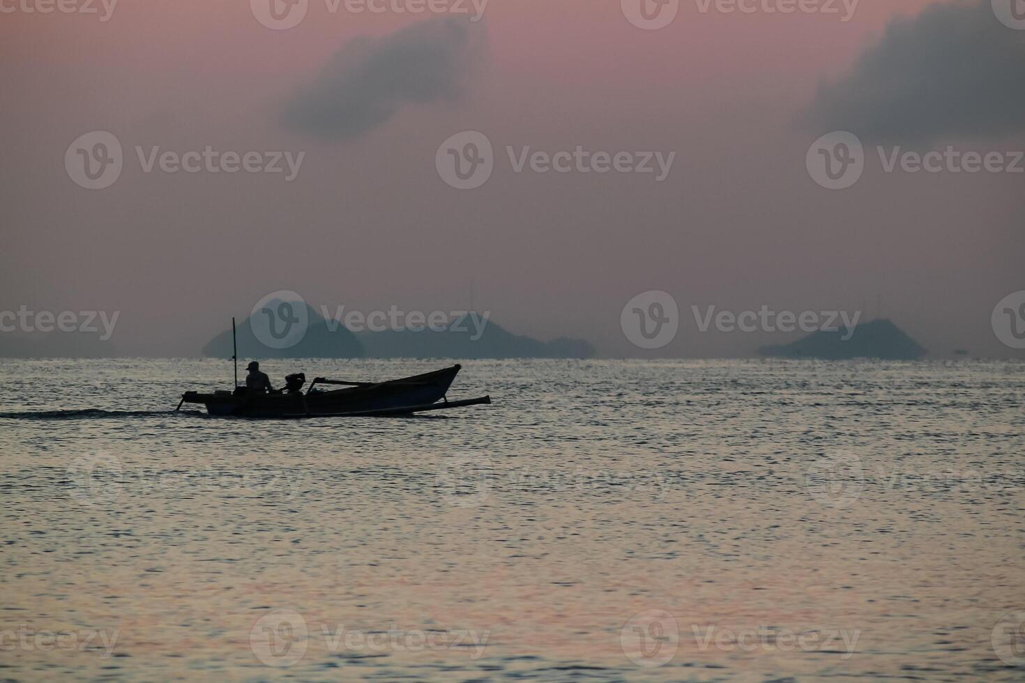 Beautiful sunrise on the sea and silhouette of a fishing boat photo