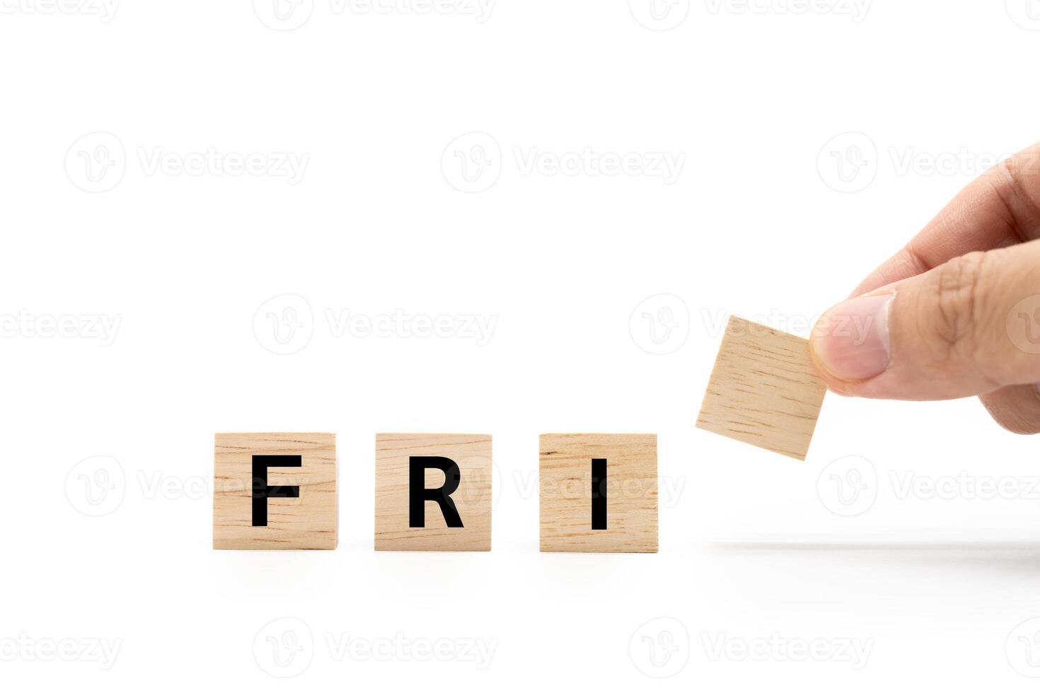 Hand place wooden blocks with FRI text isolated on white background. Friday and Calendar concept. Copy space. photo