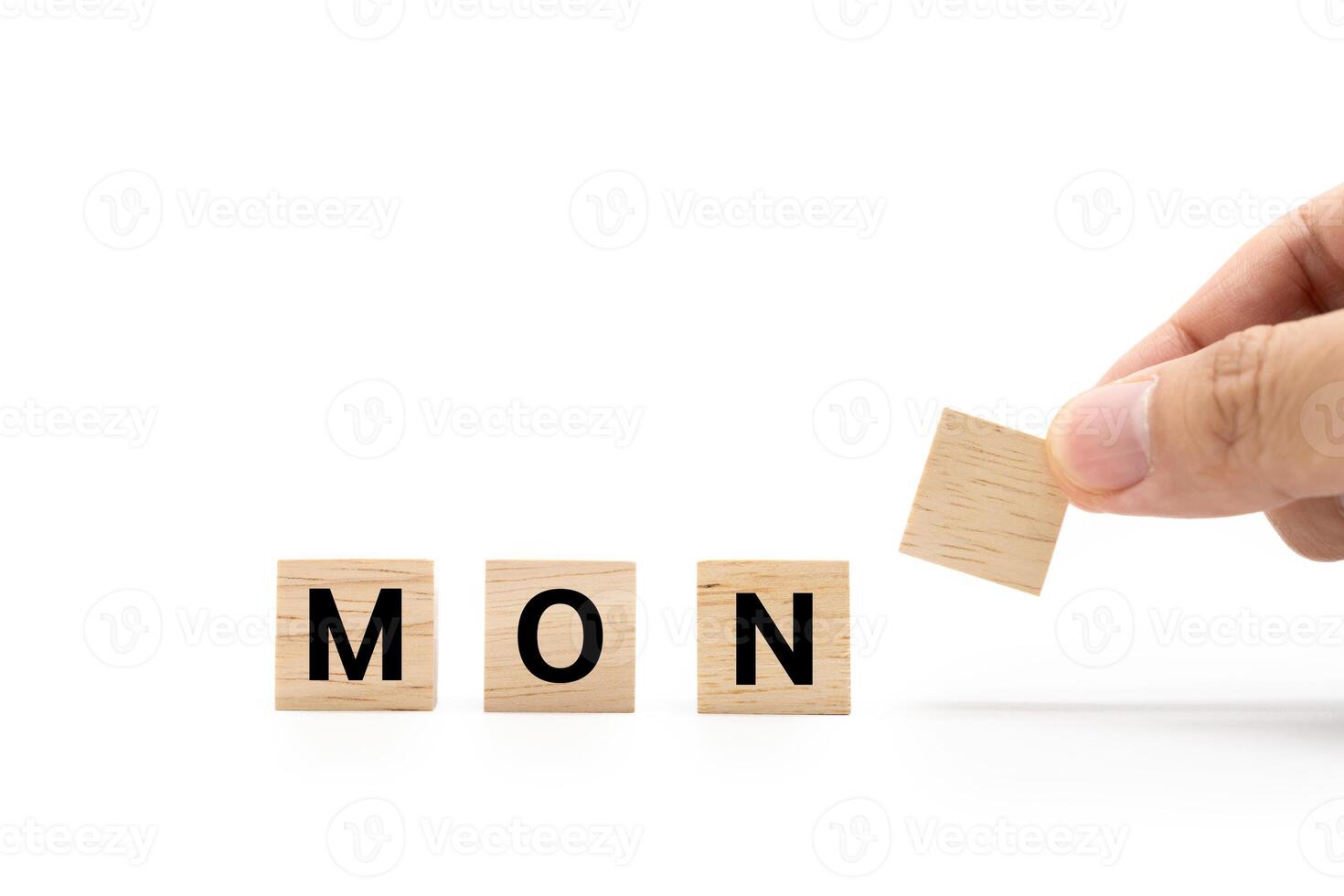 Hand place wooden blocks with MON text isolated on white background. Monday and Calendar concept. Copy space. photo