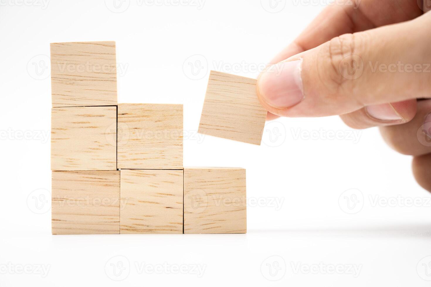 Hand putting and stacking blank wooden cubes on white background with copy space for input wording and infographic icon. photo