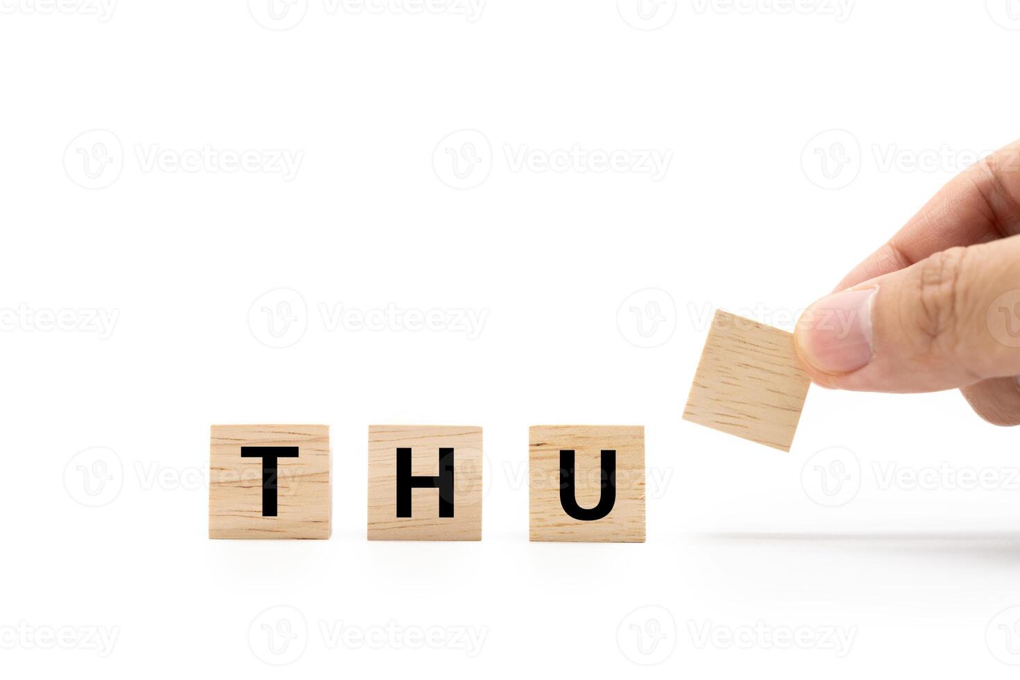 Hand place wooden blocks with THU text isolated on white background. Thursday and Calendar concept. Copy space. photo