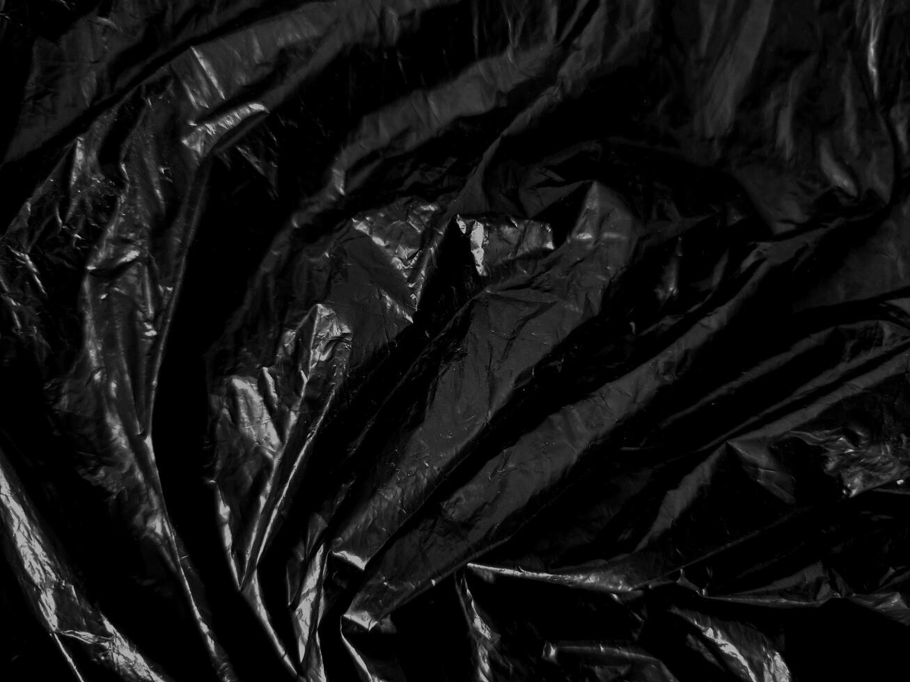 Transparent plastic wrap on the black background. Clean blank texture overlay effect template. Isolated wrinkle surface branding mock-up. photo